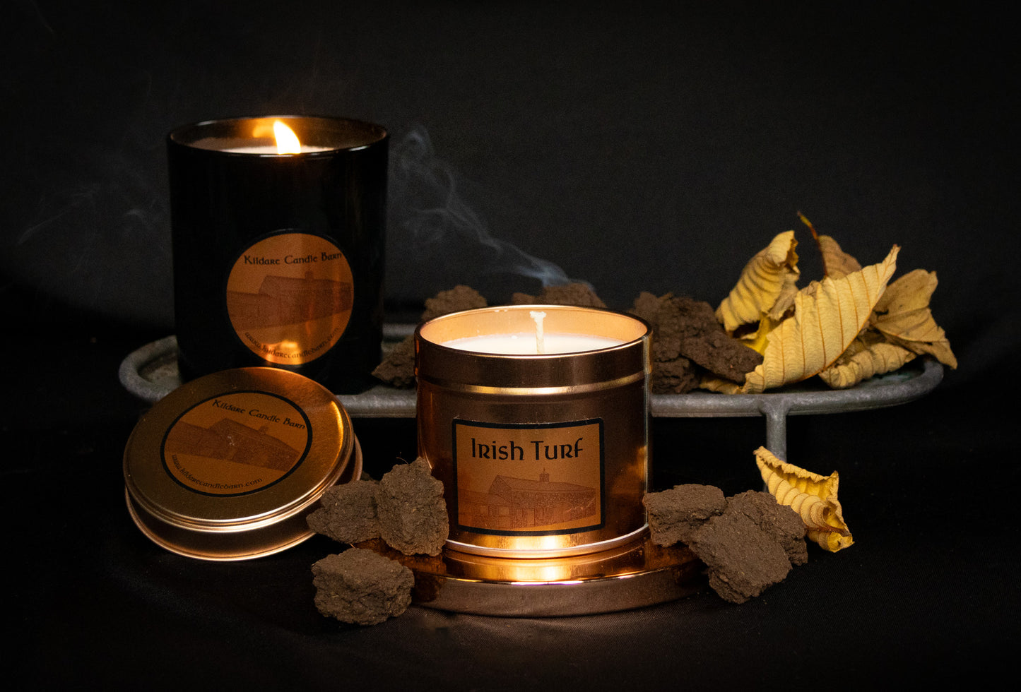 Irish Soy Wax Candles in copper tin with 'Irish Turf' branding on a dark background and smoking turf embers.