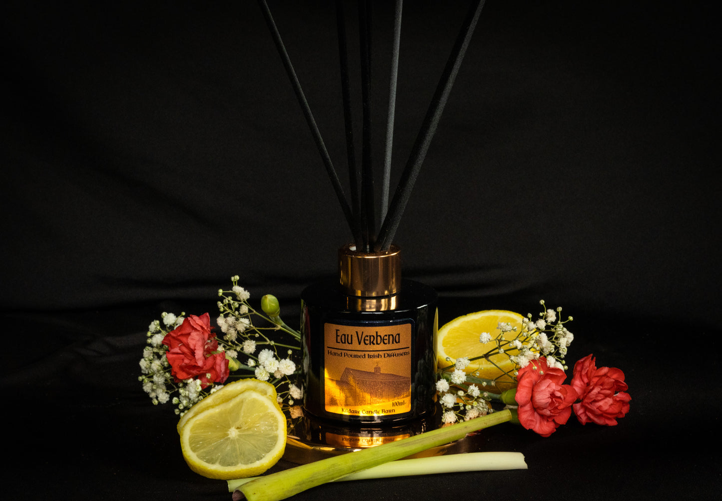 Reed diffuser with flowers and lemons on a black background