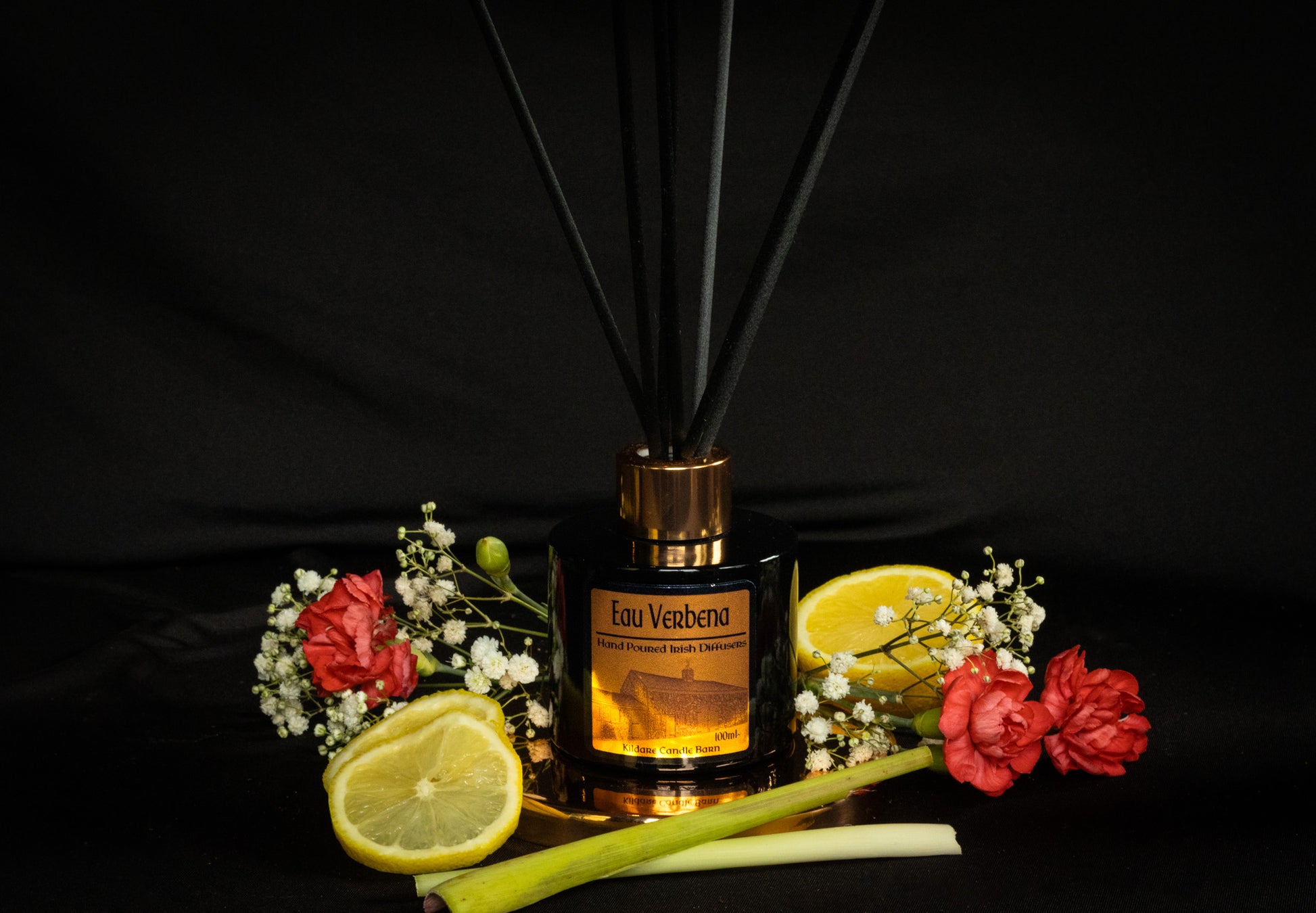 Reed diffuser with flowers and lemons on a black background
