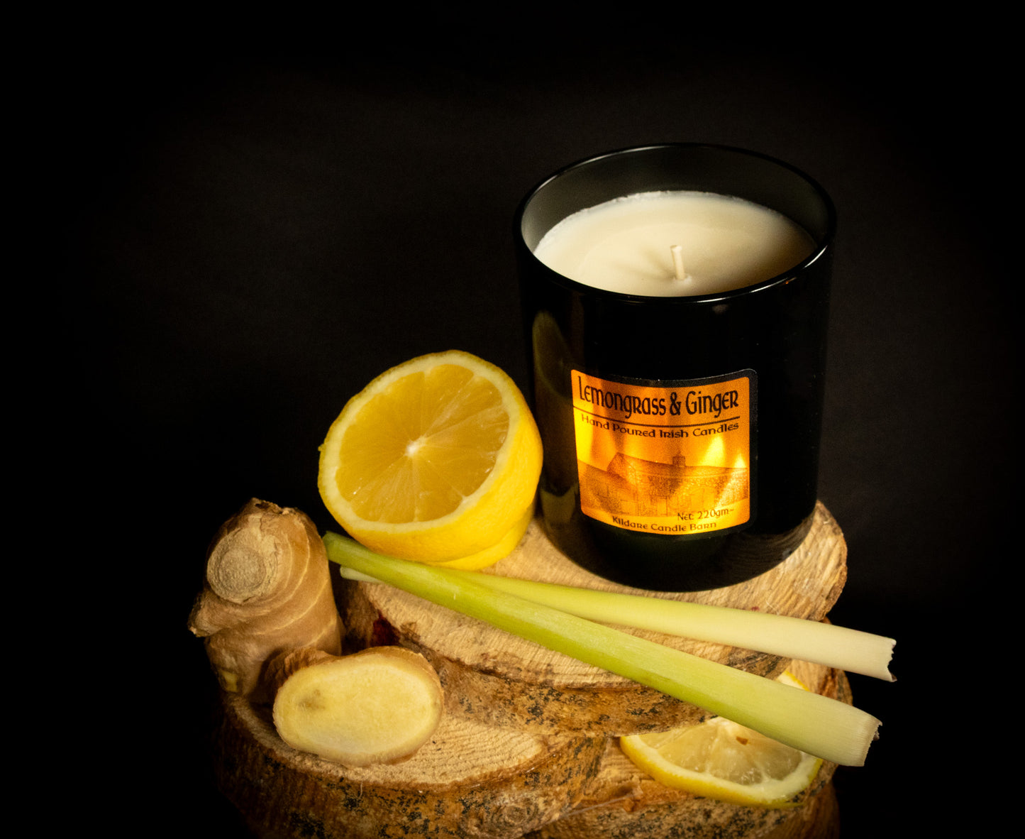 Irish Soy Wax Black Jar Candle labeled 'Lemongrass & Ginger' with lemons, ginger, and celery on a dark background