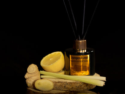 Reed diffuser with lemons, ginger, and celery on a dark background
